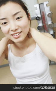 Close-up of a young woman exercising with her hands behind her head