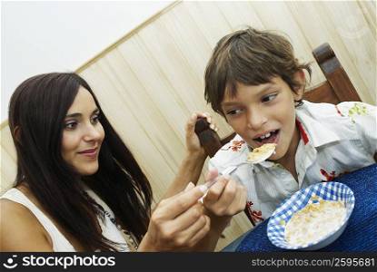 Close-up of a young woman feeding her son