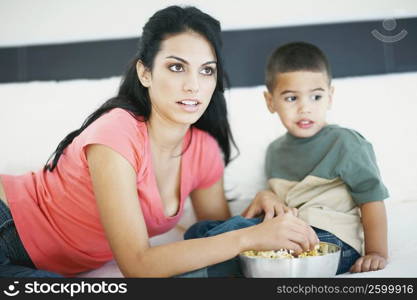 Close-up of a young woman feeding her son popcorn