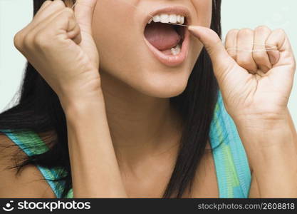 Close-up of a young woman flossing her teeth