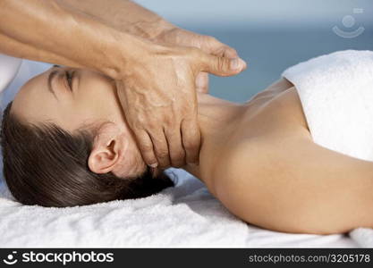 Close-up of a young woman getting a neck massage