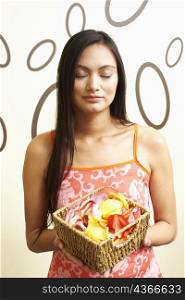Close-up of a young woman holding a basket of flower petals