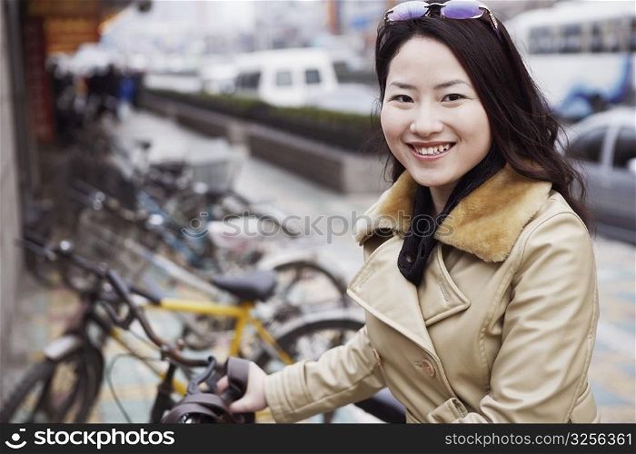 Close-up of a young woman holding a bicycle
