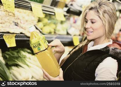 Close-up of a young woman holding a bottle of cooking oil