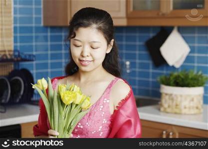 Close-up of a young woman holding a bunch of flowers smiling