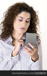 Close-up of a young woman holding a calculator
