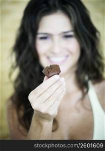 Close-up of a young woman holding a chocolate
