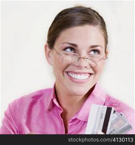 Close-up of a young woman holding a credit card and smiling
