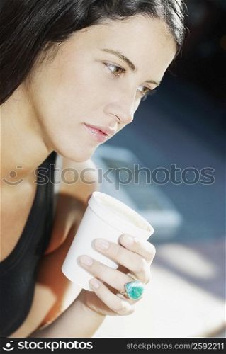 Close-up of a young woman holding a cup of coffee
