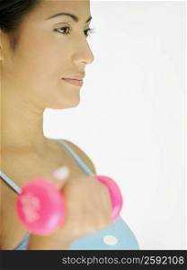 Close-up of a young woman holding a dumbbell and exercising
