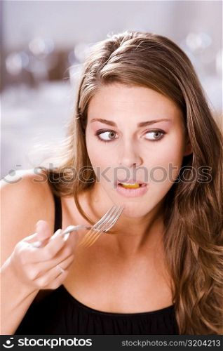 Close-up of a young woman holding a fork