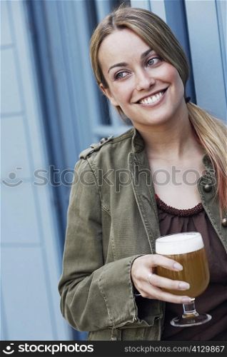 Close-up of a young woman holding a glass of beer