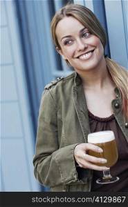 Close-up of a young woman holding a glass of beer