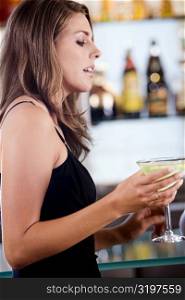 Close-up of a young woman holding a glass of cocktail