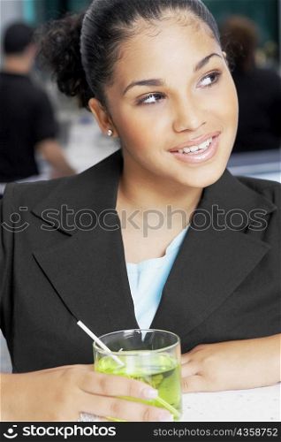 Close-up of a young woman holding a glass of cocktail