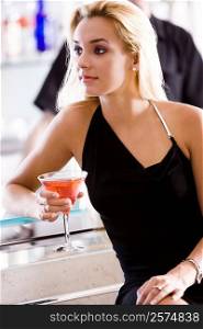 Close-up of a young woman holding a glass of martini