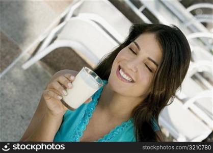 Close-up of a young woman holding a glass of milk