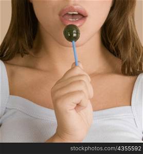 Close-up of a young woman holding a lollipop