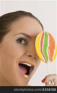 Close-up of a young woman holding a lollipop
