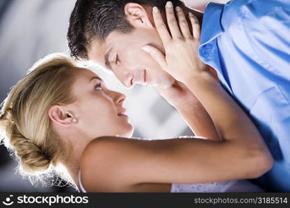 Close-up of a young woman holding a mid adult man&acute;s face