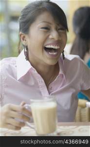 Close-up of a young woman holding a milkshake