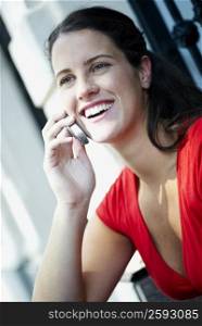 Close-up of a young woman holding a mobile phone and laughing