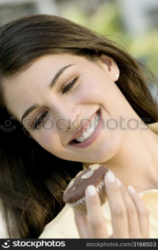 Close-up of a young woman holding a muffin