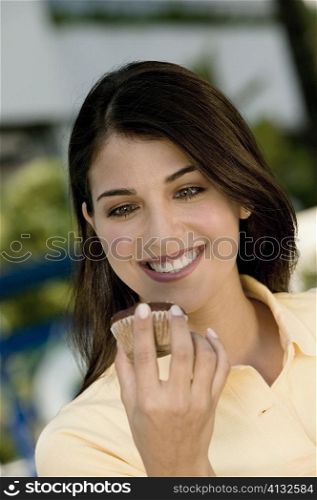 Close-up of a young woman holding a muffin