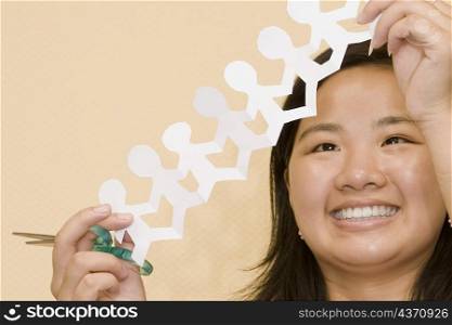 Close-up of a young woman holding a paper chain and smiling