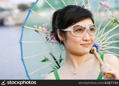 Close-up of a young woman holding a parasol