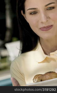 Close-up of a young woman holding a plate of muffins