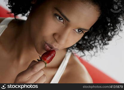 Close-up of a young woman holding a strawberry