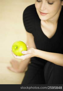 Close-up of a young woman holding an apple