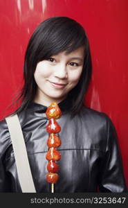 Close-up of a young woman holding avocado&acute;s on a stick