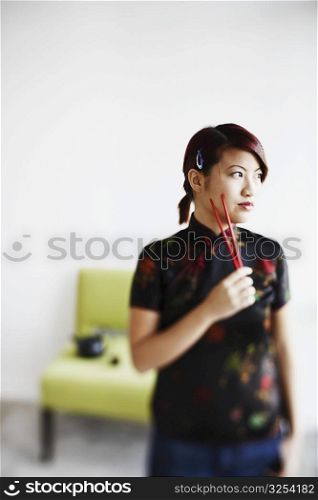 Close-up of a young woman holding chopsticks