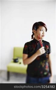 Close-up of a young woman holding chopsticks