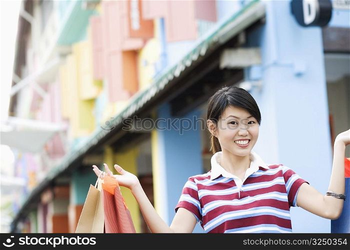 Close-up of a young woman holding shopping bags and smiling