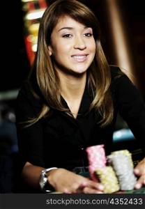 Close-up of a young woman holding stacks of gambling chips on a gambling table