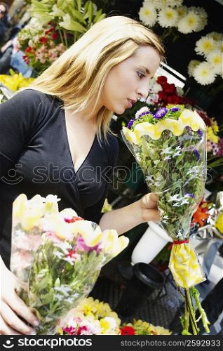 Close-up of a young woman holding two bouquets of flowers