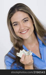 Close-up of a young woman holding US paper currency