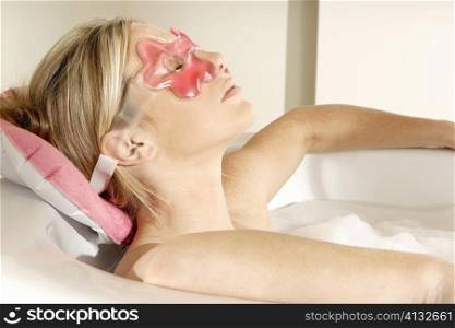 Close-up of a young woman in a bathtub with her eyes closed