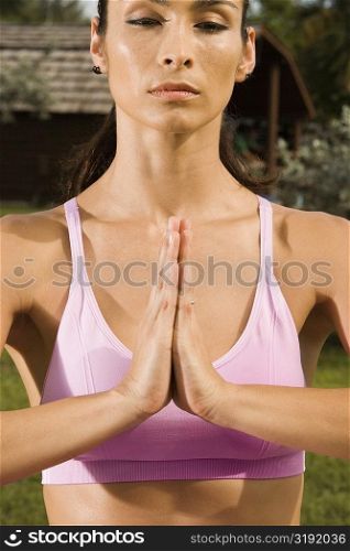Close-up of a young woman in a prayer position