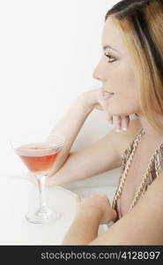 Close-up of a young woman in front of a glass of martini