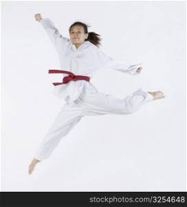 Close-up of a young woman jumping and practicing martial arts