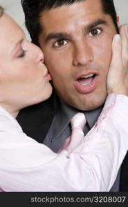 Close-up of a young woman kissing a mid adult man