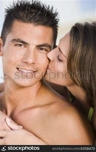 Close-up of a young woman kissing a young man