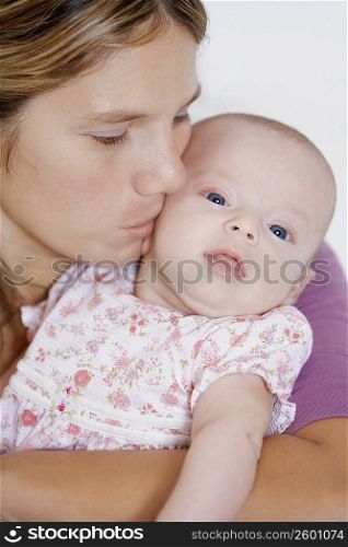 Close-up of a young woman kissing her baby girl