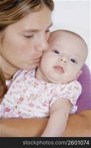 Close-up of a young woman kissing her baby girl