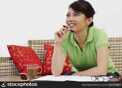 Close-up of a young woman leaning against a table and thinking