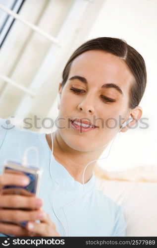 Close-up of a young woman listening to an MP3 player